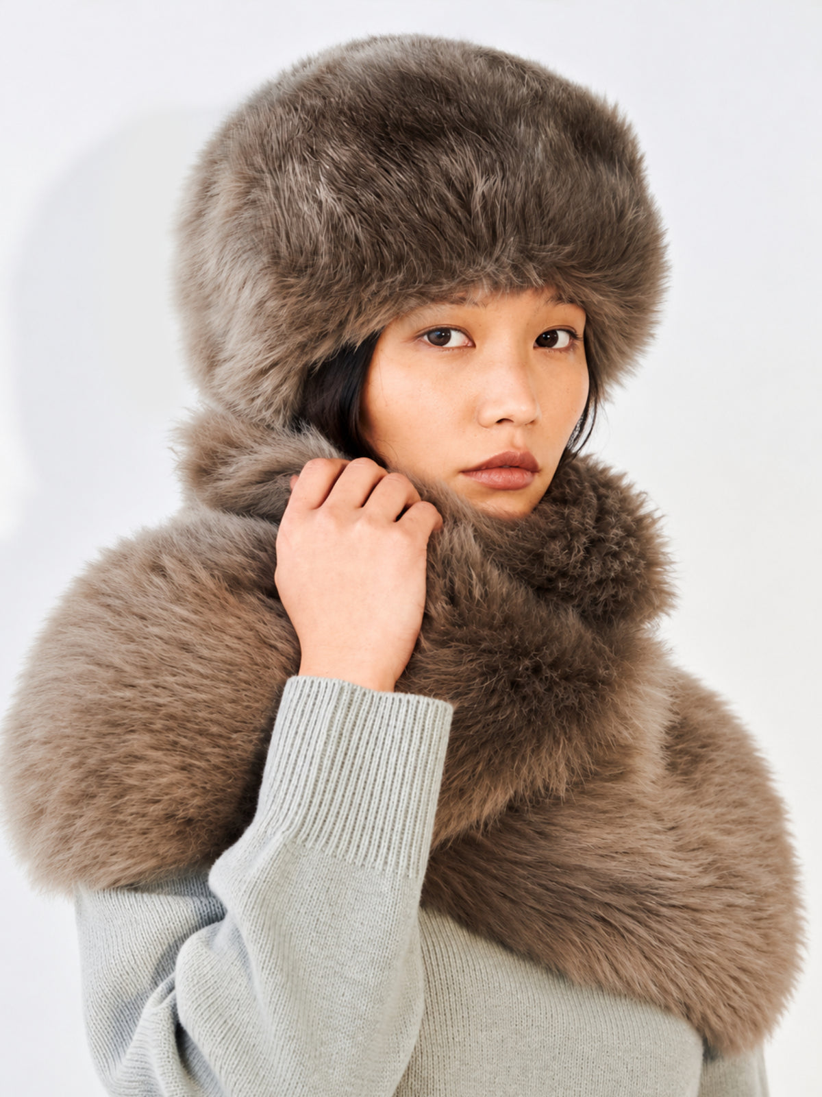 A close-up of a model wearing a brown fur Pill Box hat
