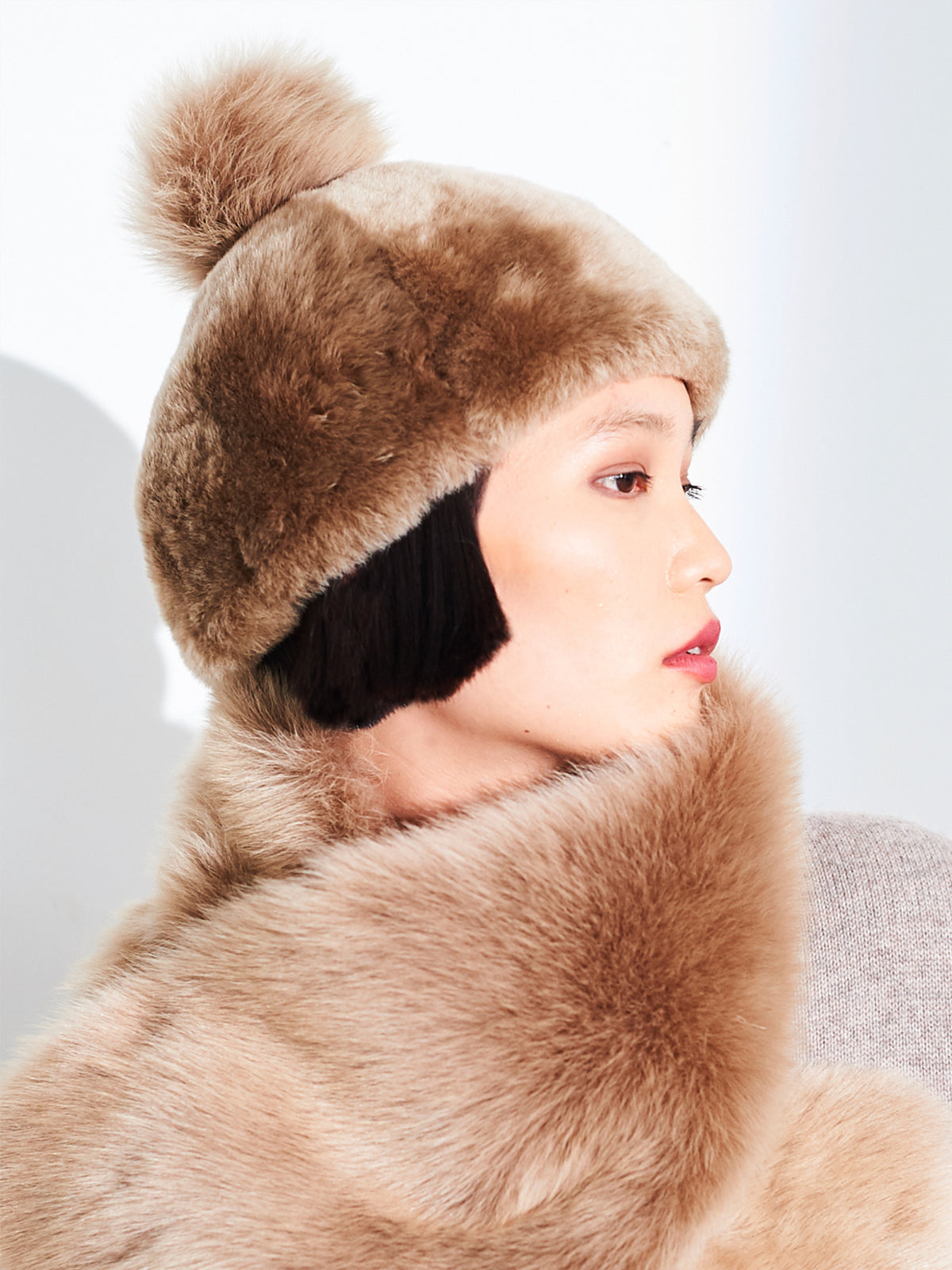 Beige Toscana pompom hat by Dom Goor on a model, side profile close-up
