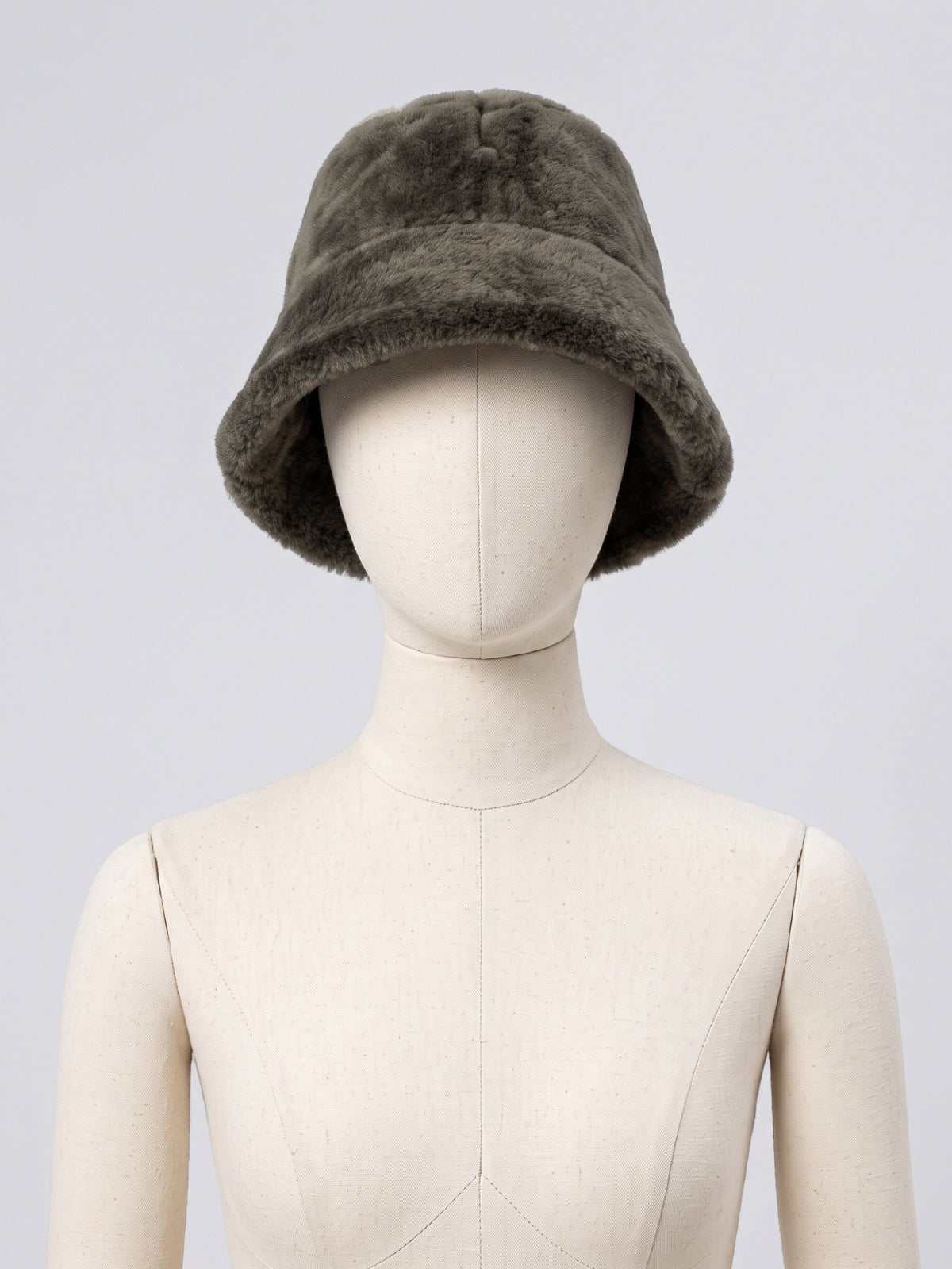 Olive shearling bucket hat by Dom Goor displayed on a mannequin