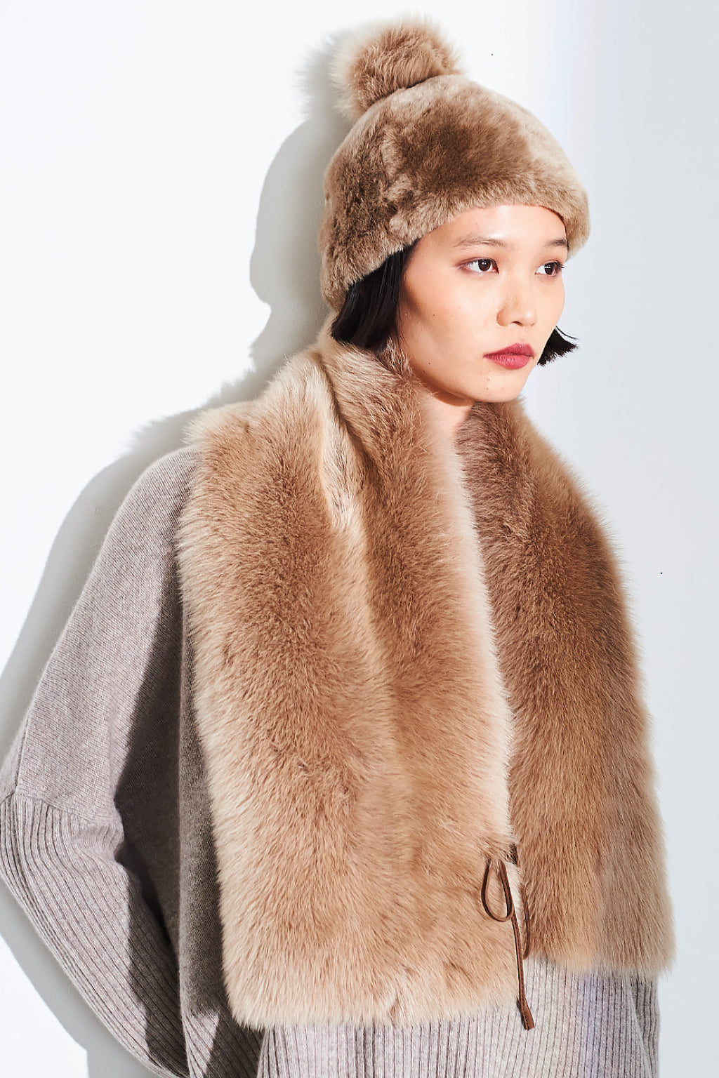 Beige Toscana scarf by Dom Goor worn long with the side tie visible, three-quarter view on a model
