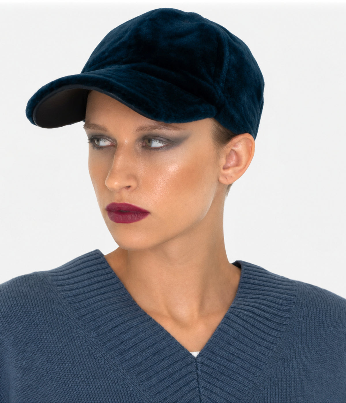 Cerulean blue shearling baseball cap by Dom Goor on a model, side angle showing the peak