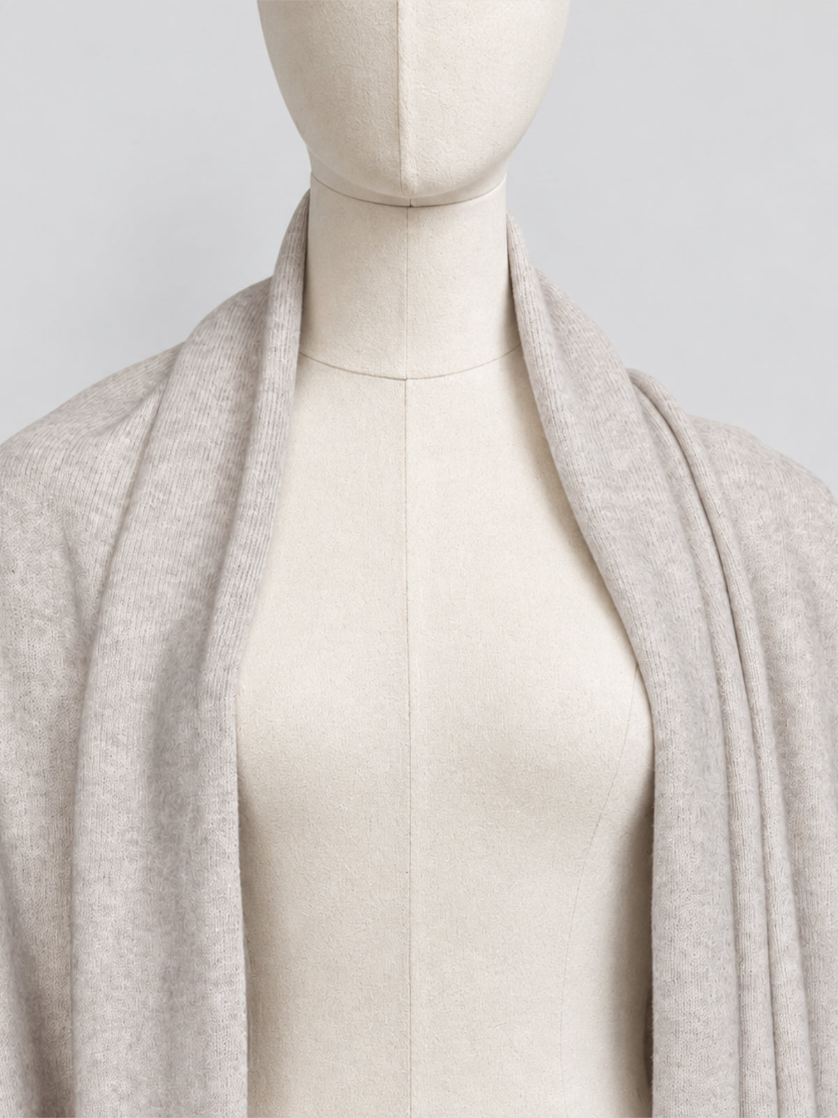 Close-up of the Dom Goor Oyster Donegal Merino wool scarf draped on a mannequin