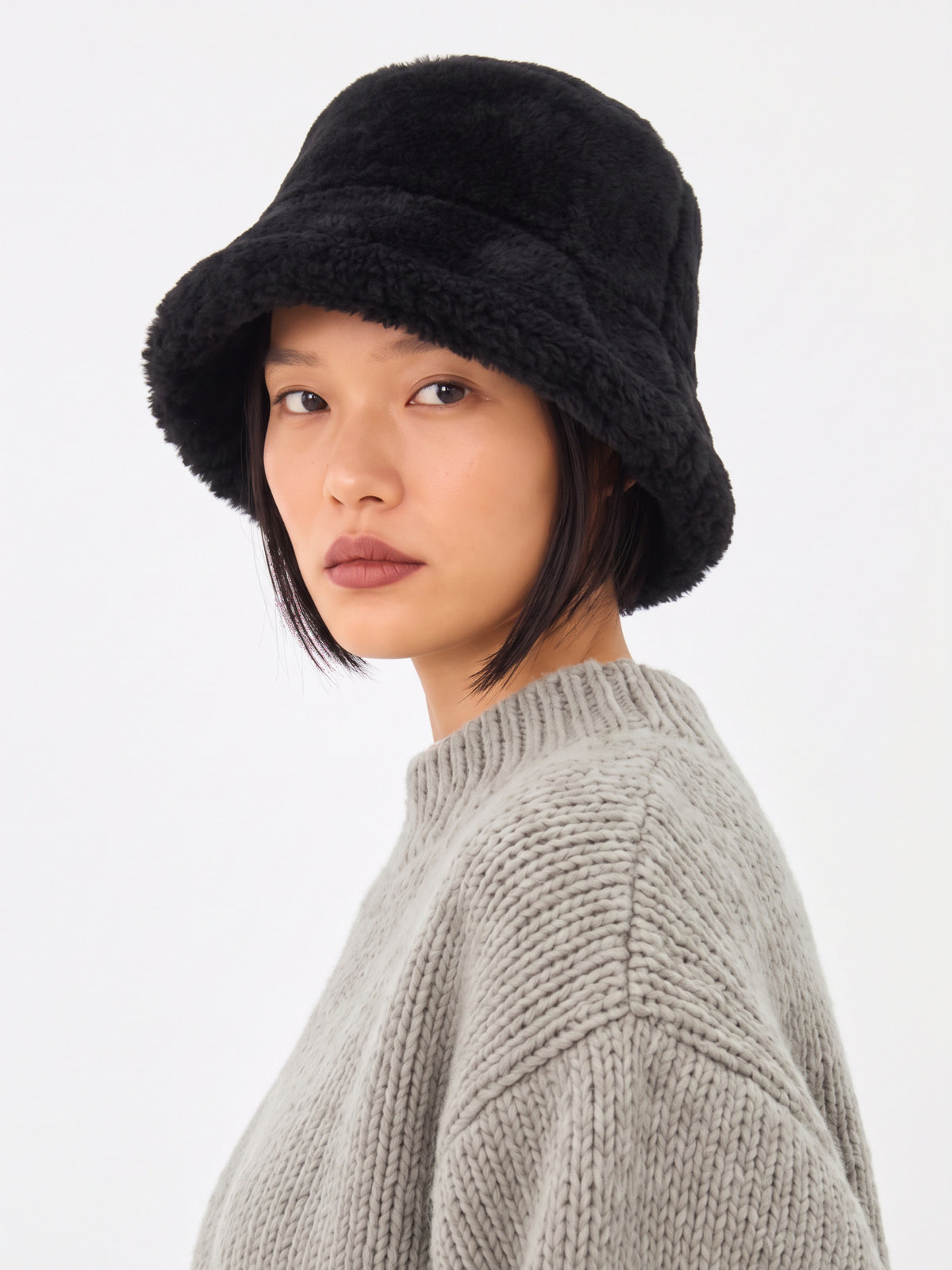Black shearling bucket hat by Dom Goor on a model, three-quarter angle