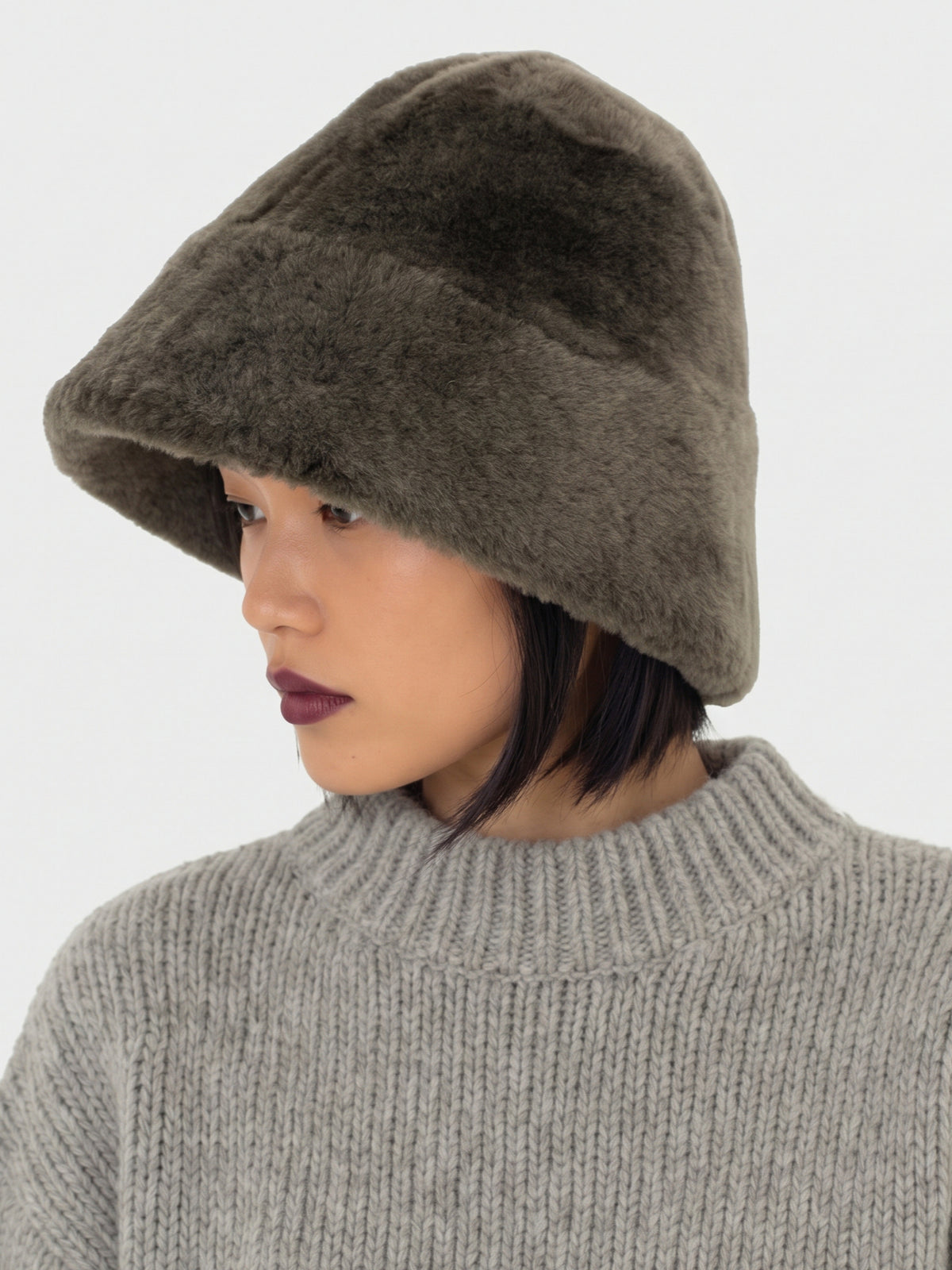 Olive shearling bucket hat by Dom Goor on a model, side profile showing the brim